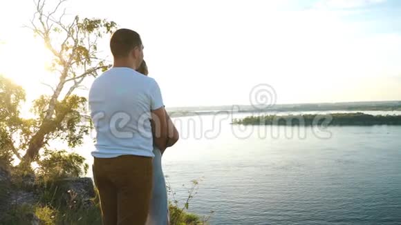 在浪漫的散步中男人向远处的悬崖展示女孩的手指视频的预览图