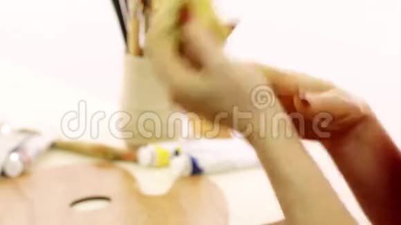 这位女士为油画颜料浸渍颜料艺术家用油擦手白色背景艺术家关门视频的预览图