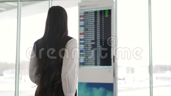 旅行妇女在机场使用智能手机年轻的白种人旅行者用手机应用程序检查登机时间视频的预览图