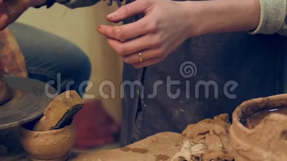 双手合拢在车轮上制作陶器视频的预览图
