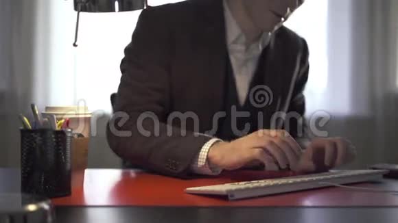 男人在办公桌上工作接电话视频的预览图