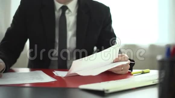 男人在办公桌上做文书工作的笔记视频的预览图