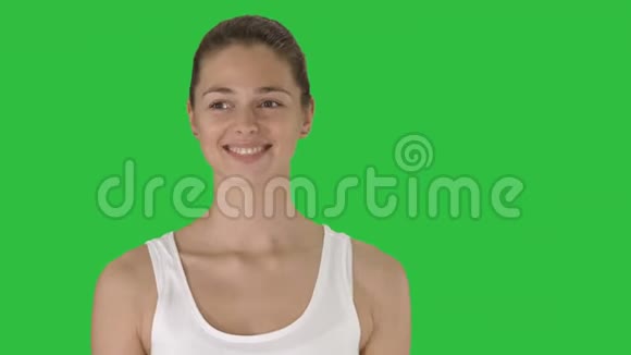 幸福的年轻女子微笑着看着相机走在绿色屏幕上Chroma键视频的预览图
