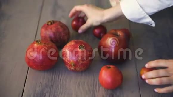 人手放新鲜水果厨师把新鲜苹果石榴和李子放在木桌上视频的预览图