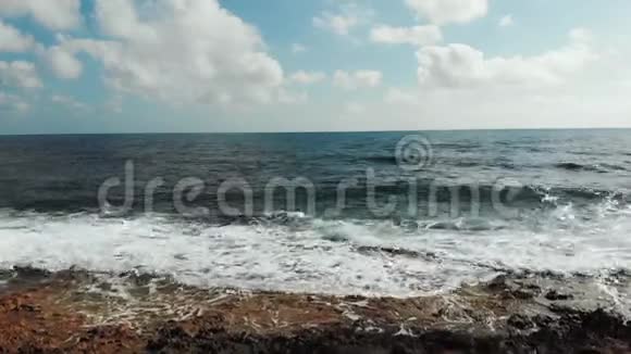 海浪的无人机击打岩石滩海浪拍打海滩的鸟瞰图视频的预览图