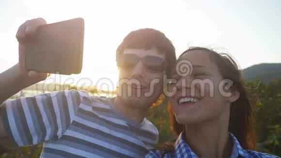 浪漫夫妇在度假期间日落时拍摄自拍视频慢动作1920x1080视频的预览图