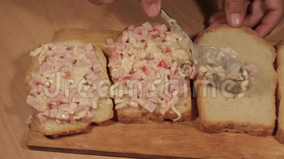 厨师把准备好的馅料放在小麦面包上做开放式三明治视频的预览图