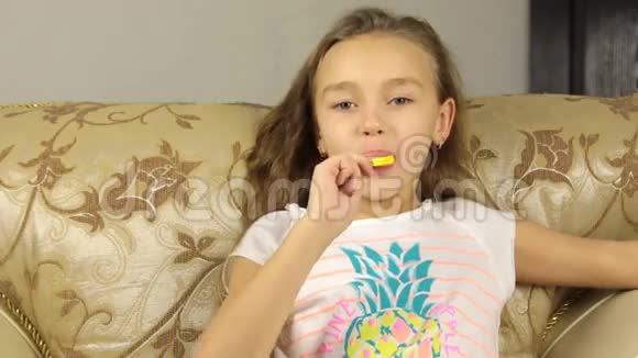 女孩用柠檬和微笑的形式在棍子上舔糖果视频的预览图