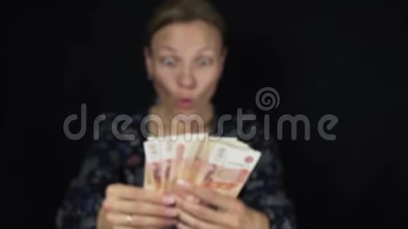 热情的女人在黑色背景上扔钞票五千卢布快乐的大堆钱慢动作股票视频的预览图