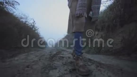 一个女孩的腿在树林里的土路上行走视频的预览图