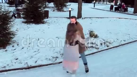 可爱的情侣在溜冰场溜冰时拿着一束花视频的预览图