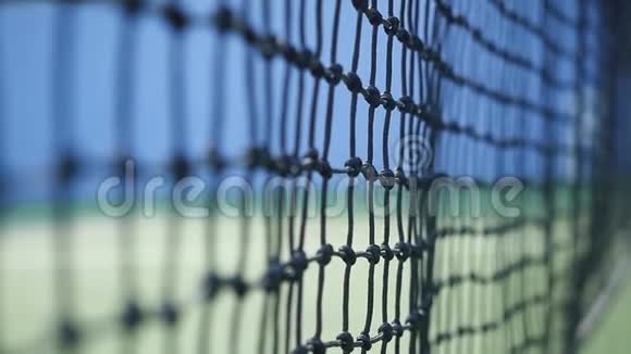 在阳光明媚的日子里网球以缓慢的运动击中了落在网球场上的球网特写视频的预览图