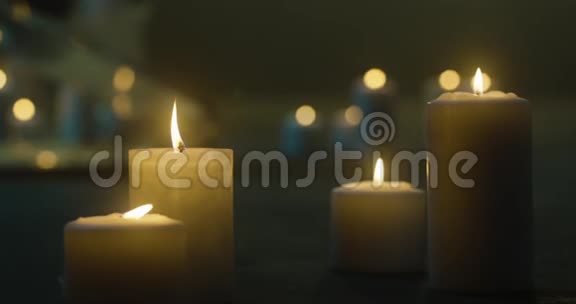 地板上有很多燃烧的蜡烛蜡烛在黑暗中燃烧玻璃烛台蜡烛的黄色火焰烛台视频的预览图