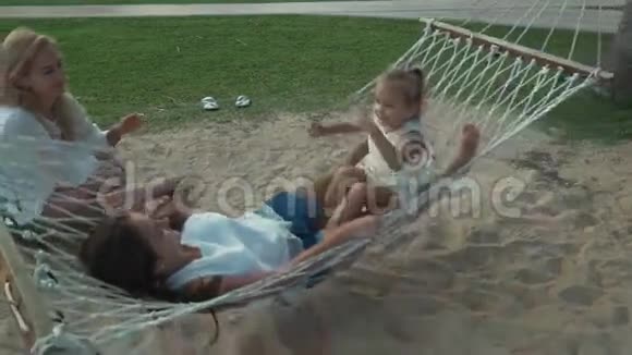 快乐妈妈摇着女儿吊床慢动作股票录像视频的预览图