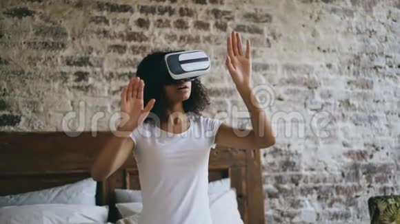 年轻的非洲女性在家里使用VR360耳机眼镜体验虚拟现实视频的预览图