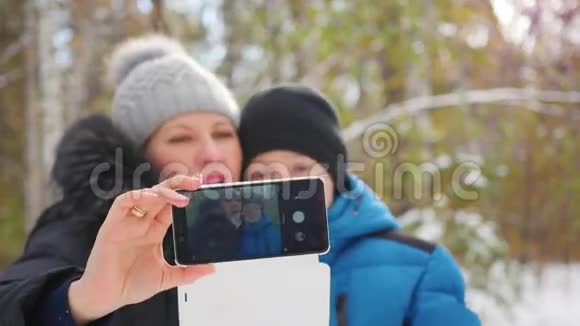 快乐的一家人在冬天公园自拍视频的预览图