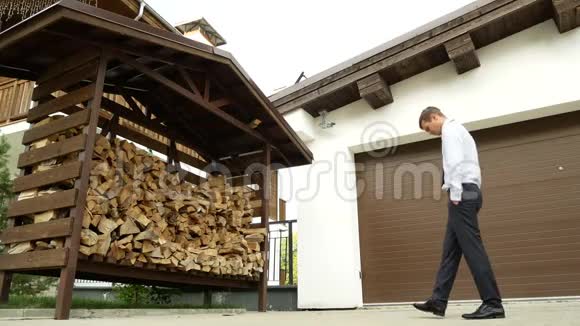 生态概念思想中的商人绕着准备过冬的木柴走来走去4k视频的预览图