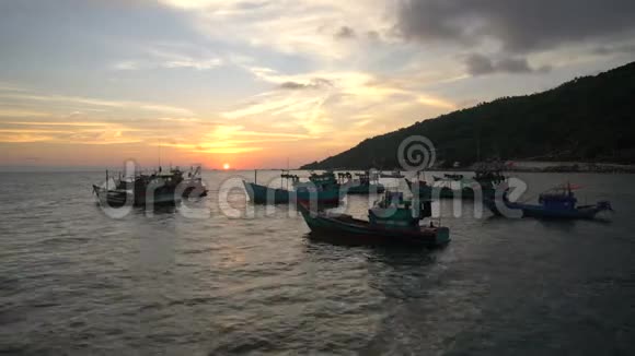 越南传统渔船的剪影漂浮在风景优美的蓝色海面上映衬着金色的夕阳视频的预览图