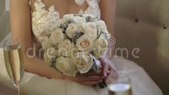 穿着婚纱坐在沙发上捧着花束的白人年轻新娘视频的预览图