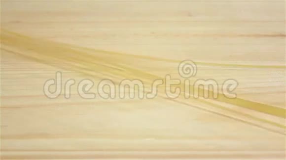 长长的意大利面落在木桌上慢动作视频的预览图