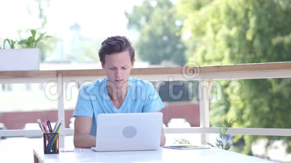 在工作中为疲惫的设计师打哈欠坐在户外视频的预览图