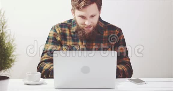 使用笔记本电脑和喝咖啡的胡须男视频的预览图