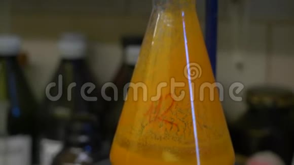 科学实验室玻璃锥形Erlenmeyer烧瓶中装满琥珀橙化学液体进行化学实验视频的预览图