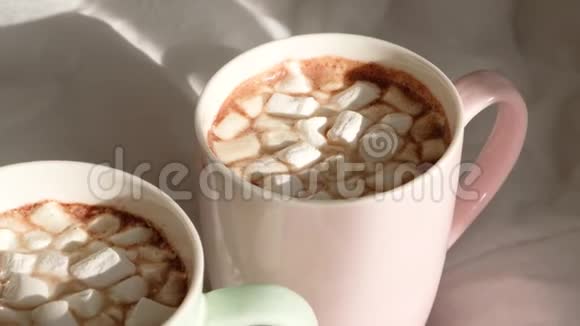两杯热巧克力和棉花糖在床上早上好世界视频的预览图
