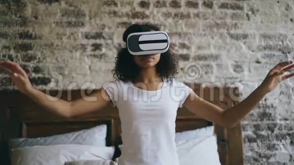 年轻的混血女孩在家使用VR360耳机眼镜体验虚拟现实视频的预览图