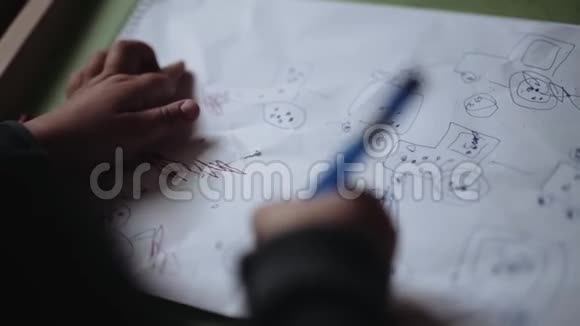 小男孩用铅笔在纸上画画视频的预览图