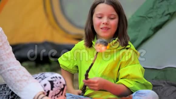 女孩在篝火上烤棉花糖视频的预览图