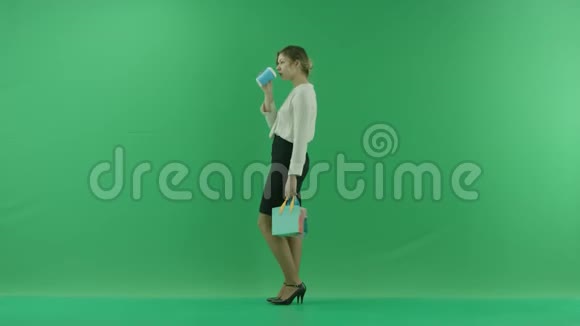 漂亮的购物妇女正拿着购物袋从纸杯里喝咖啡女顾客拿着购物袋视频的预览图