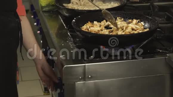 在慢动作的煤气炉上在餐厅厨房的煎锅或平底锅中煮炸薯条炸鸡片肉视频的预览图