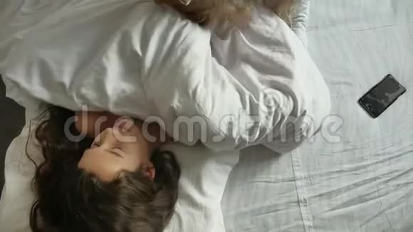 小可爱的女孩和狗在室内睡觉睡在床上的小女孩黑黑肤色的生活方式有趣视频的预览图