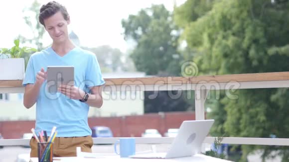 站在阳台上的年轻人在线视频聊天视频的预览图