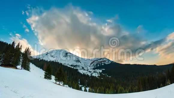 在美丽的山区地形中冬天的日落时间随着云和雪而流逝视频的预览图