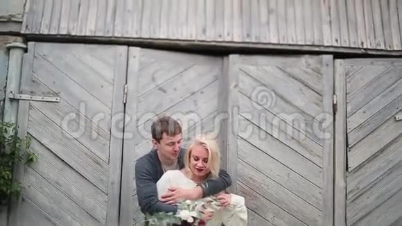 一对拥抱在木门背景上的情侣视频的预览图