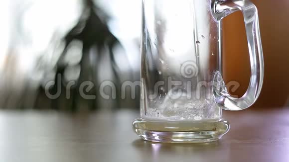 啤酒倒在桌子上半个空杯子里视频的预览图