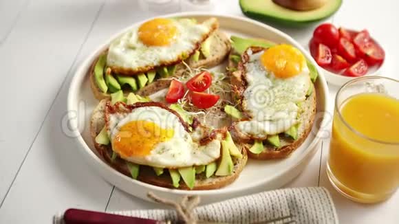 美味的健康早餐有牛油果切片三明治和煎蛋视频的预览图