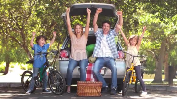 一家人在有自行车的车前快乐视频的预览图