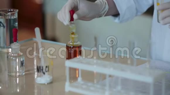 科学家将红色液体滴入试管的特写镜头把液体从吸管中倒入管子视频的预览图