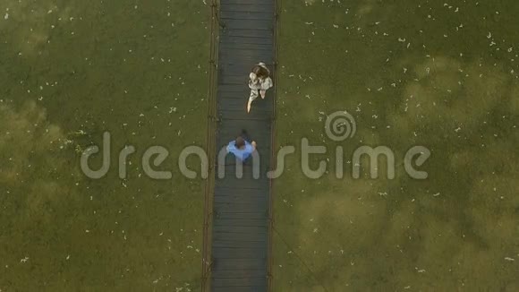 在山上的一座木桥上相爱的夫妇晨雾慢镜头视频的预览图