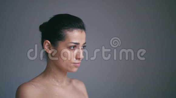 美女模特女孩肖像美丽的女人脸孤立在灰色背景上美丽的女孩抚摸她的脸视频的预览图
