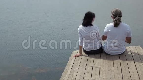 男人和女人坐在桌上看着湖视频的预览图