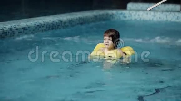 孩子们在游泳池里游泳小男孩在休闲中心的游泳池里游泳视频的预览图