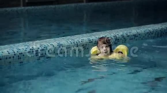 小男孩在休闲中心的游泳池里游泳视频的预览图