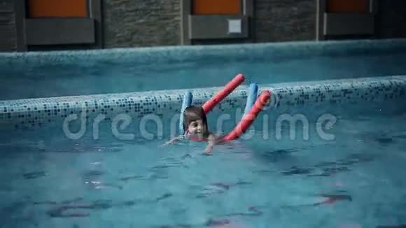 小男孩在休闲中心的游泳池里游泳视频的预览图