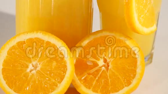 孤立的饮料一杯橙汁和在白色背景下分离的橙果片视频的预览图