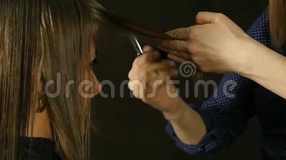 专业的理发师在发廊中将女性客户的头发剪成刘海慢动作视频的预览图