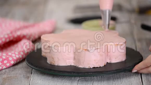 糕点厨师正在做一个粉红色的蛋糕形状像一朵花系列视频的预览图